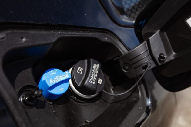 A person refilling AdBlue in a diesel car tank.