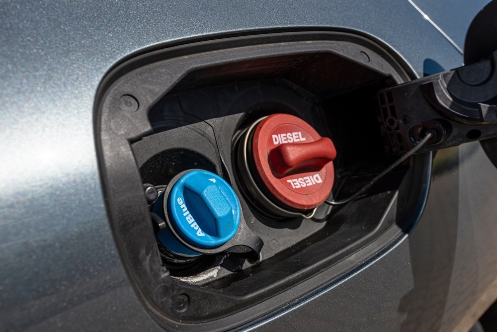 A person refilling AdBlue in a diesel car tank.