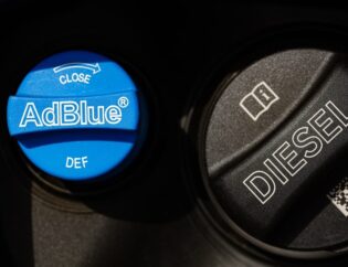 A container of Diesel Exhaust Fluid being poured into a truck’s DEF tank.