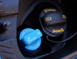 A fuel nozzle with an AdBlue label near a petrol engine.