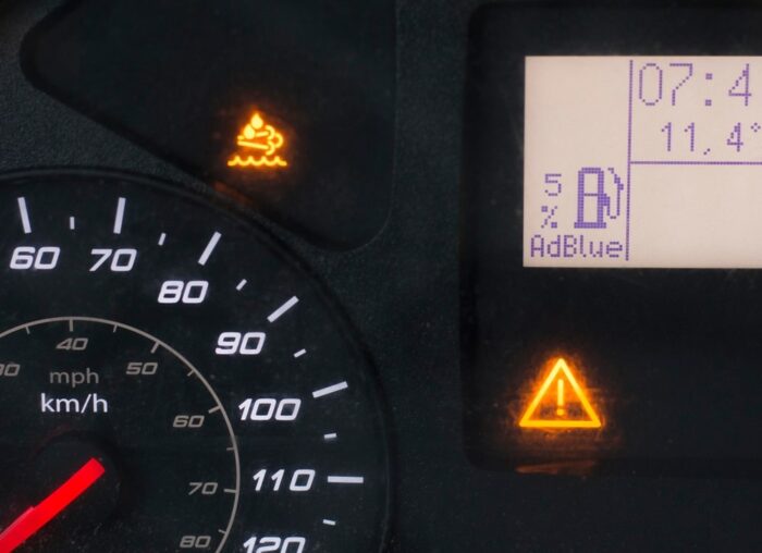 Car dashboard showing AdBlue warning light being reset after refill