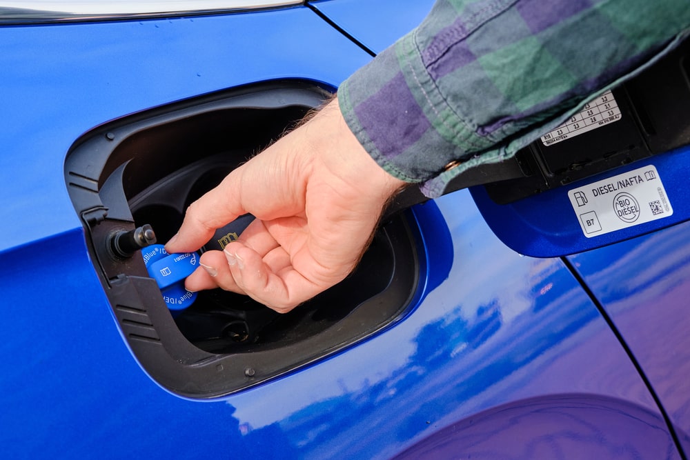 Mechanic inspecting a diesel engine AdBlue injector and SCR system.