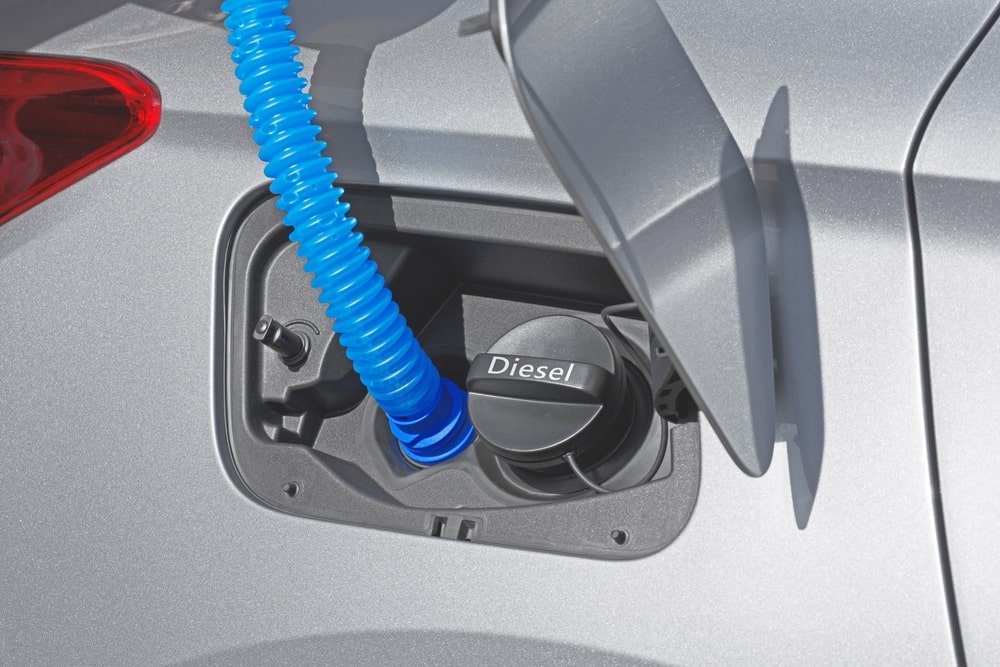 Person reading a safety label on a container of diesel exhaust fluid