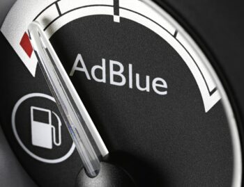 Mechanic installing an SCR canister and diesel exhaust fluid injector on an older diesel exhaust system