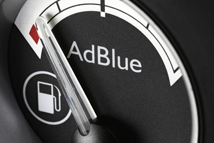 Mechanic installing an SCR canister and diesel exhaust fluid injector on an older diesel exhaust system