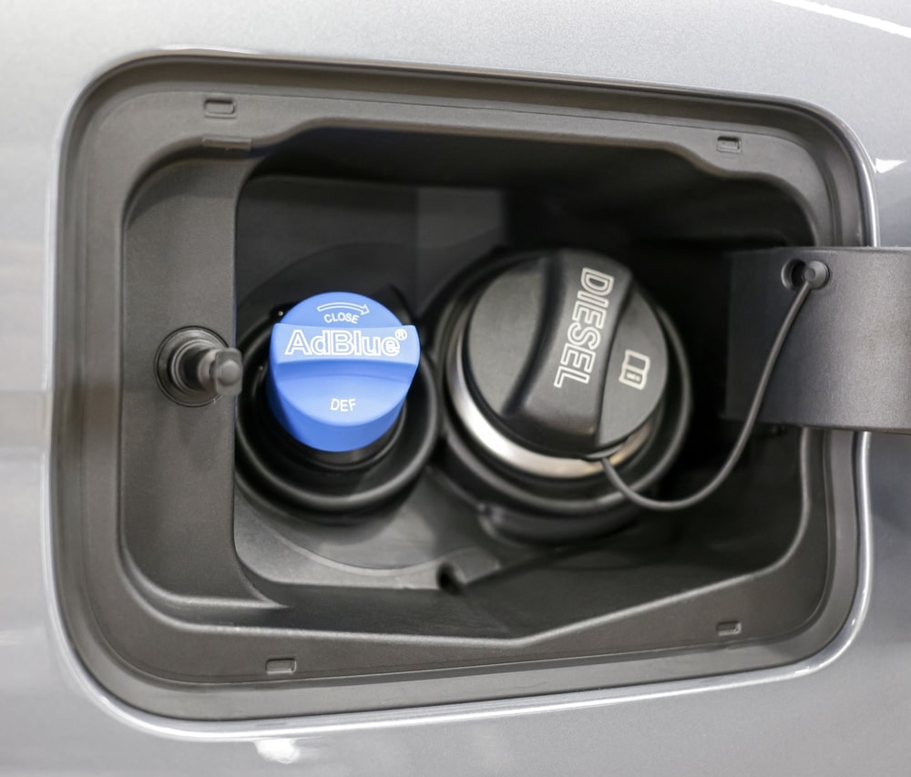 Mechanic installing an SCR canister and diesel exhaust fluid injector on an older diesel exhaust system
