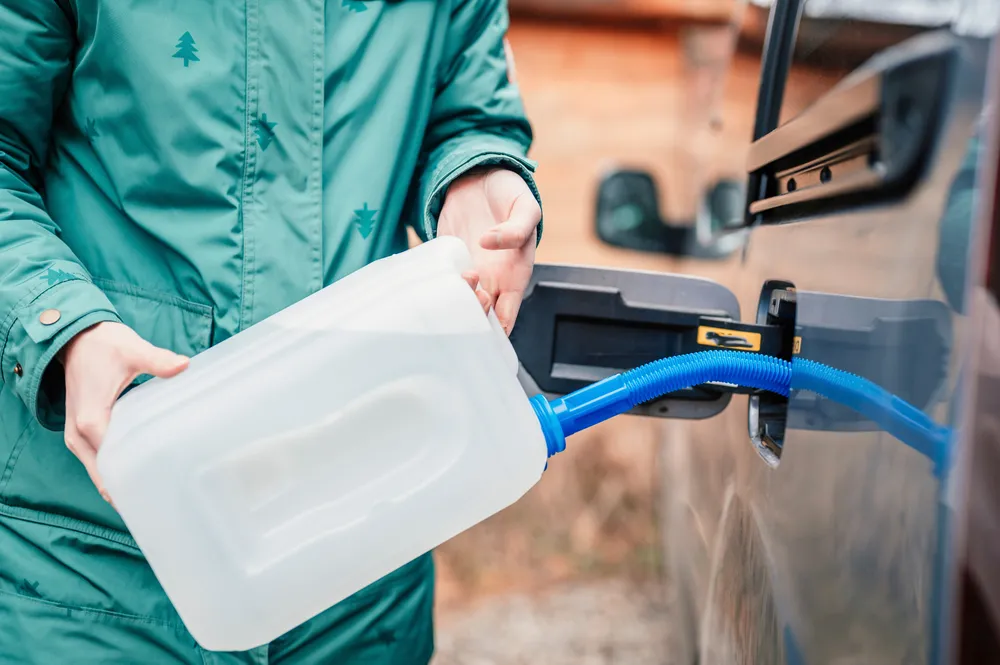 Technician examining high-purity diesel exhaust fluid in a production facility